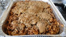 a casserole dish filled with meat and crumbs on top of aluminum foil