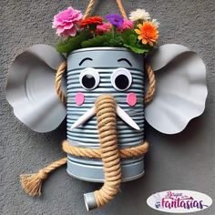 an elephant made out of tin cans with flowers in it's trunk and eyes