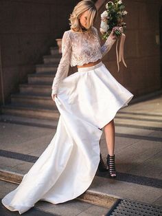 a woman in a white dress is walking down the stairs with her hand on her hip