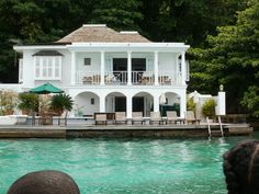 a large white house sitting on top of a body of water