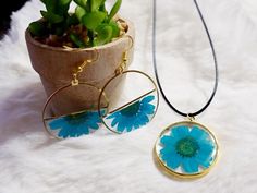 Blue Daisy Resin Hoops Earrings and Necklace Set This exquisite earrings and necklace set showcase real daisies preserved in crystal-clear resin, capturing the intricate details of each petal. The gold circle design adds a modern touch, making the earrings and necklace a perfect blend of nature-inspired beauty and contemporary style. This makes the perfect gift for mother's day, birthday or just any occasion.  Care instructions: Clean with a soft jewelry polishing cloth, do not use jewelry cleaner. Do not store in direct sunlight. Remove before showering, swimming, working out or sleeping. Avoid getting aerosol sprays or perfumes on the items. Hypoallergenic All earrings and necklaces are handmade by me and there may be minor variations. Colors may vary slightly from photos. Contact me if Bohemian Personalized Round Jewelry, Bohemian Style Personalized Round Jewelry, Handmade Bohemian Jewelry Gift For Mom, Hypoallergenic Pendant Jewelry Gift, Handmade Dainty Flower Jewelry, Minimalist Flower Jewelry With Pressed Flowers, Handmade Blue Necklaces As Gift For Mom, Bohemian Pendant Jewelry For Mother's Day, Hypoallergenic Pendant Jewelry Gift For Her