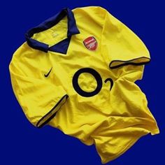 a yellow nike shirt with the word o on it and a smiley face drawn in black