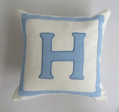 a blue and white pillow with the letter h on it