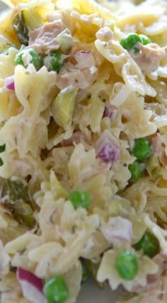 a white plate topped with pasta salad and peas