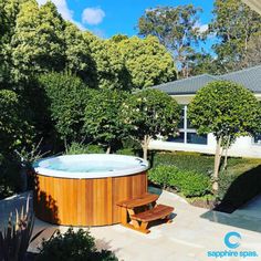 an outdoor hot tub surrounded by trees and shrubs