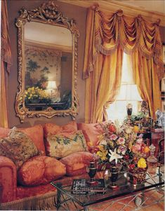 a living room filled with furniture and a large mirror on the wall over a coffee table