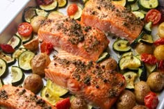 salmon and vegetables on a baking sheet ready to be cooked in the oven for dinner