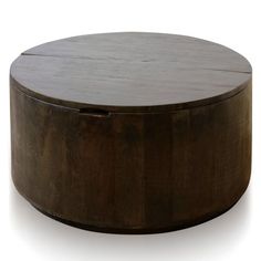 a round wooden table sitting on top of a white floor