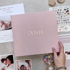 a woman's hand is touching the cover of a pink album with photos on it