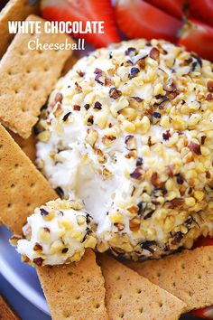 white chocolate cheese ball with crackers and strawberries in the background on a plate