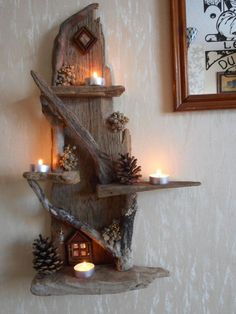 a candle holder made out of wood with pine cones and candles in it on the wall