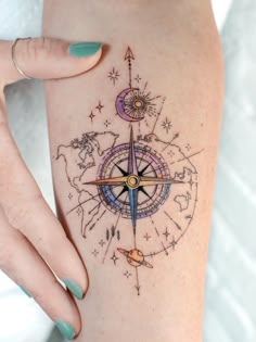 a woman's arm with a compass tattoo on it