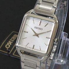 From The Essentials Collection. With A Fresh Square Case Design, This Light And Slim Watch Is Proportioned For A Perfect Fit. The Silver-White Die-Stamped Grid Pattern Dial And Subtly Textured Markers Add A Hint Of Sophisticated Luxury. Crafted Of Stainless Steel With Tri-Fold Push Button Release Clasp. Fits Up To 7 1/2” Wrist. This Watch Is New In Box With Tags And Works As It Should. Condition: New Case Size: 26mm X 35mm Case Thickness: 6.4 Mm Band Width: 15 Mm Band Length: 7 Inches. Clasp: Tr Slim Watches, Silver Watches Women, Grid Pattern, Case Design, Square Watch, Tri Fold, Push Button, Silver Watch, Quartz Watch