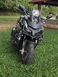 a motorcycle parked in the grass under a canopy