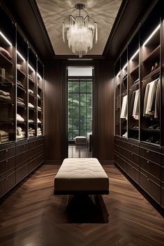 a walk - in closet with wooden flooring and shelves filled with clothes, chandelier