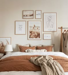 a bedroom with pictures on the wall above the bed