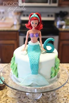 a little mermaid cake sitting on top of a counter