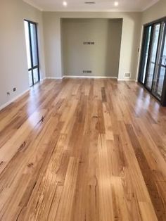 an empty living room with wood floors and sliding glass doors