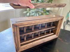 a person is holding an old fashioned wooden radio with keys in it's display case