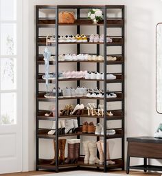 a shoe rack with many pairs of shoes on it in the corner of a room