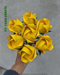 a person holding a bunch of yellow flowers in their hand with the caption, it's paper crafts