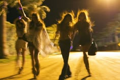 three women are running down the street at night