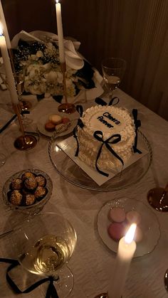 a birthday cake on a table with candles and other desserts in front of it