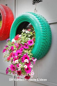 the tire is hanging from the wall with flowers in it