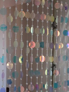 a close up of a curtain made out of glass beads and plastic balls hanging from it's sides