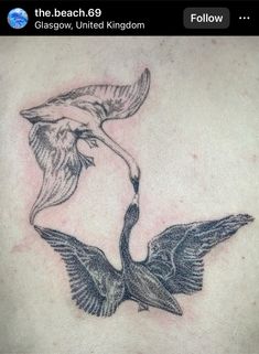 the back of a woman's stomach with two birds flying over it and one is holding