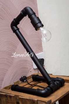 a black lamp sitting on top of a wooden table