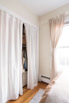 a bedroom with white curtains and a bed