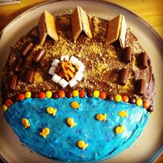 a birthday cake decorated to look like a beach with chocolate and marshmallows