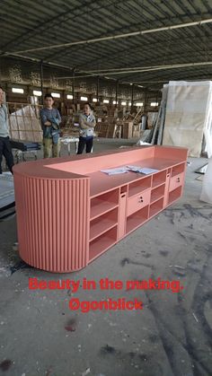 an orange entertainment center in a warehouse with people looking at it and the words beauty in the making