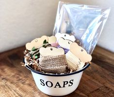 a white bucket filled with soaps on top of a wooden table