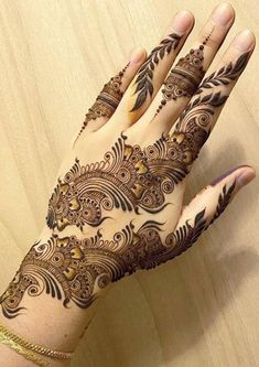 a woman's hand with henna tattoos on it