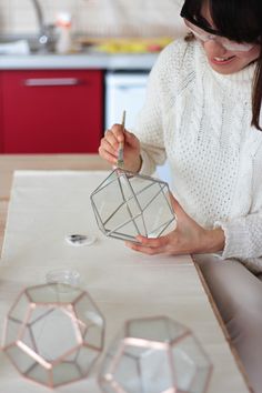 a woman is working on some geometric shapes