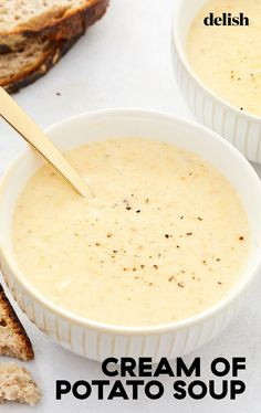 two white bowls filled with cream of potato soup next to slices of toasted bread