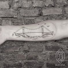 a man's arm with a drawing of a bridge on it