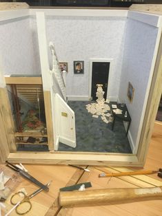 a doll house is shown with tools on the floor