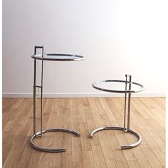 two glass tables sitting on top of a wooden floor