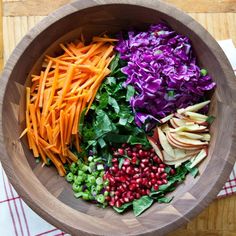 a wooden bowl filled with different types of vegetables