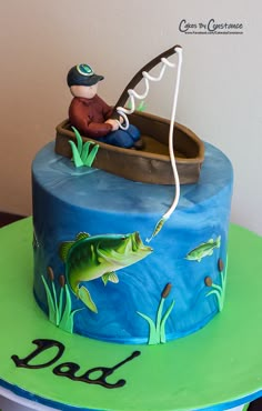 a birthday cake with a fisherman in a boat and fish on the bottom, holding a fishing rod