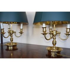 two brass table lamps with blue shades on them