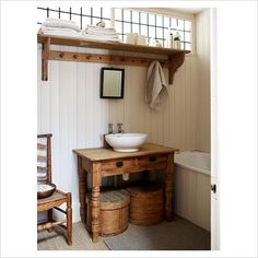 a bathroom with a sink, mirror and bathtub next to a wooden shelf on the wall