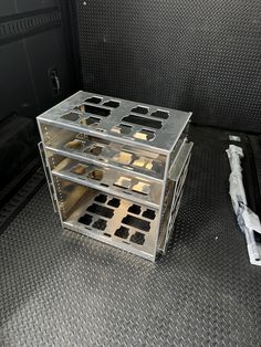 the inside of a truck with metal trays and tools on the floor next to it