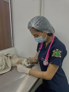 a woman in scrubs is petting a cat on the counter next to a window