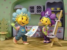 two cartoon characters standing in front of a doll house with flowers on their head and one holding a paintbrush