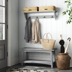 a white bench sitting under a window next to a potted plant and coat rack