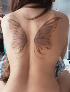 the back of a woman's body with wings drawn on her upper and lower half